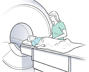 Boy lying on back on scanner table. Healthcare provider is preparing table to go into ring-shaped opening.